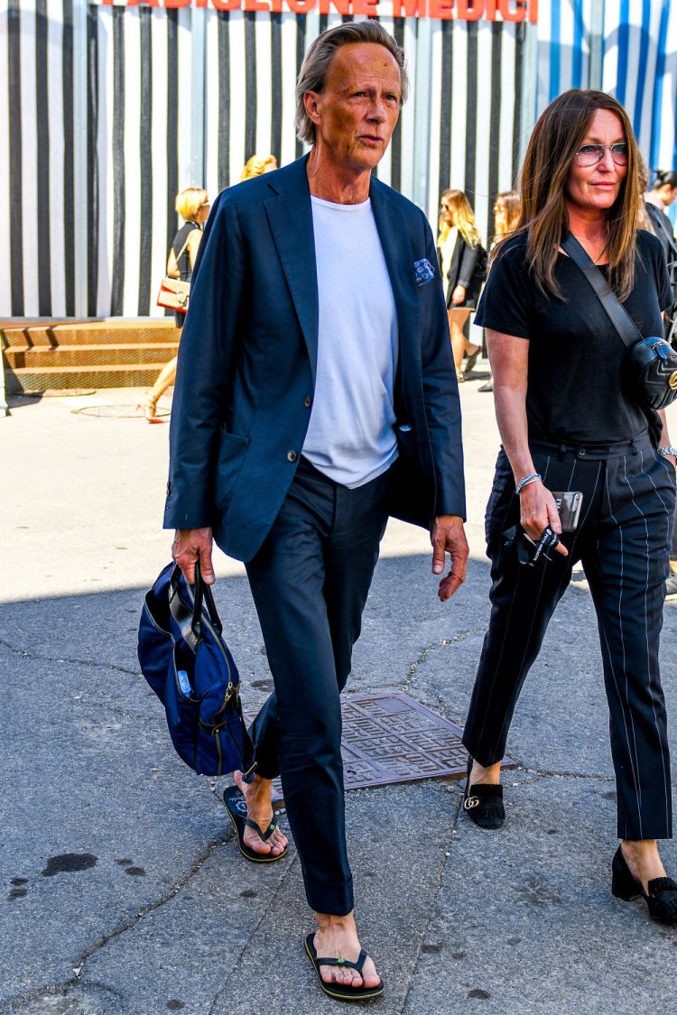 Men's code dressing with a suit, T-shirt and sandals for a casual down-to-earth look.