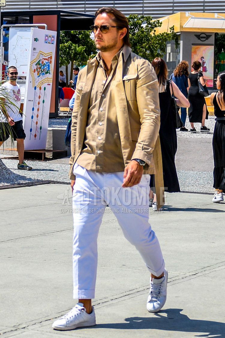 A summer-spring-fall men's coordinate outfit with solid color sunglasses, solid color beige other, solid color beige shirt, solid color white slacks, and white low-cut sneakers.