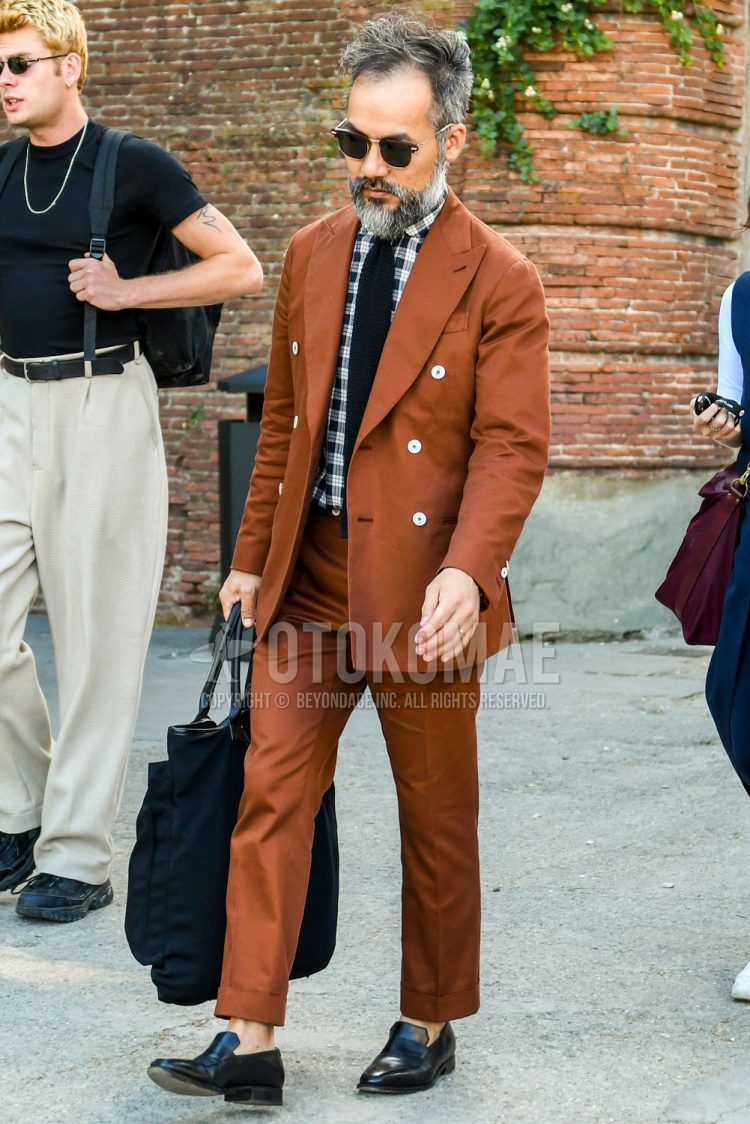 A summer/spring/fall men's coordinate outfit with plain black sunglasses, white/black checked shirt, black coin loafer leather shoes, plain black tote bag, plain brown suit, and plain knit tie.