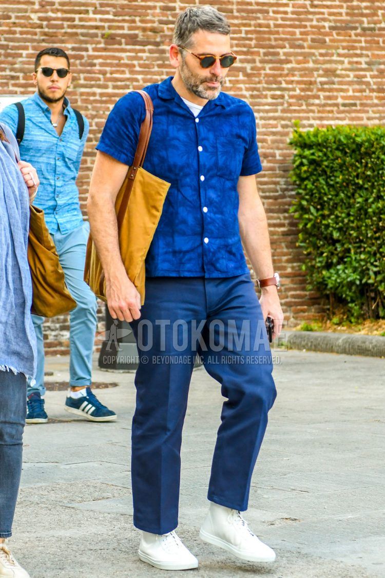 べっ甲のサングラス、ブルーその他のシャツ、白無地のTシャツ、ネイビー無地のチノパン、白ハイカットのスニーカー、ベージュ無地のトートバッグを合わせた夏のメンズコーデの着こなし。