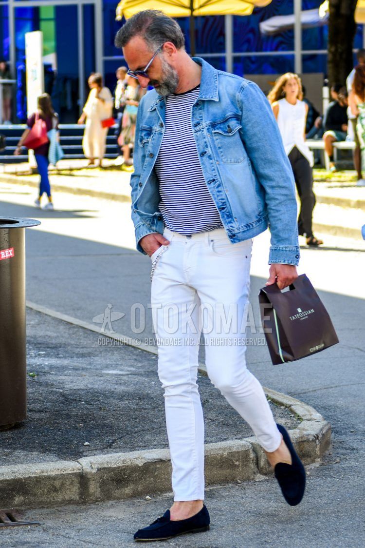 Spring, summer and fall men's coordinate outfit with solid color sunglasses, solid color blue denim jacket, striped t-shirt, solid color white denim/jeans, navy tassel loafers leather shoes, navy suede shoes leather shoes.
