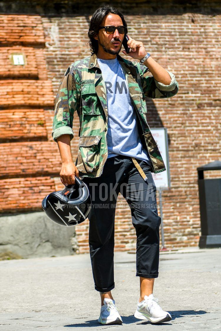 A summer-spring-fall men's coordinate outfit with plain sunglasses, camouflage safari jacket, gray one-pointed t-shirt, plain black cropped pants, and Nike Zoom Fly white low-cut sneakers.