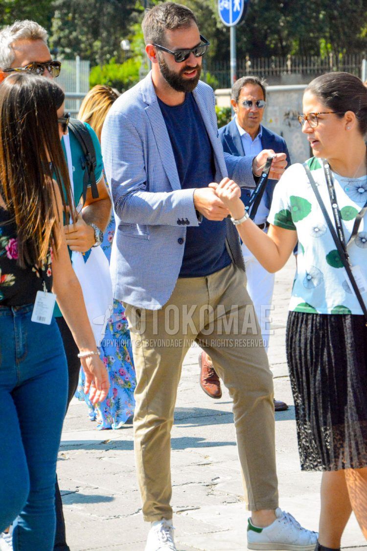 Spring, summer and fall men's coordinate outfit with plain sunglasses, blue checked tailored jacket, plain navy t-shirt, plain beige chinos and Adidas Stan Smith white low-cut sneakers.