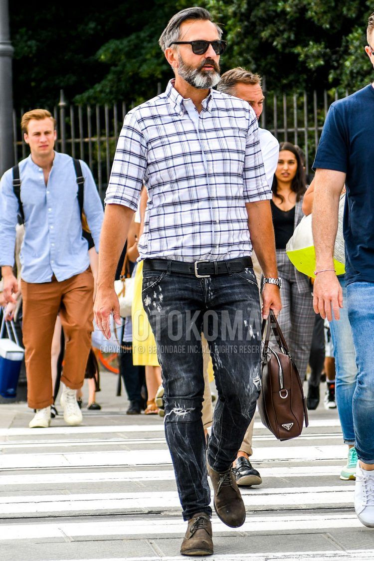 A summer/spring men's outfit with plain sunglasses, white checked shirt, plain black leather belt, plain gray/black denim/jeans, beige suede shoes leather shoes, and plain brown briefcase/handbag.