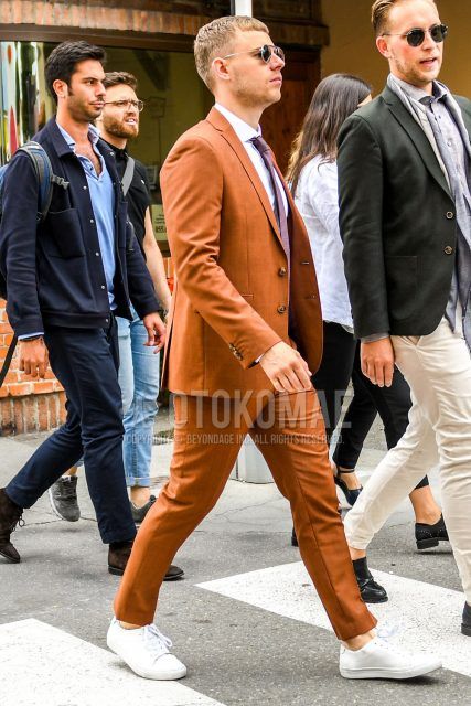 Spring, summer and fall men's coordinate outfit with plain gold sunglasses, plain white shirt, white low-cut sneakers, plain brown suit and plain purple tie.