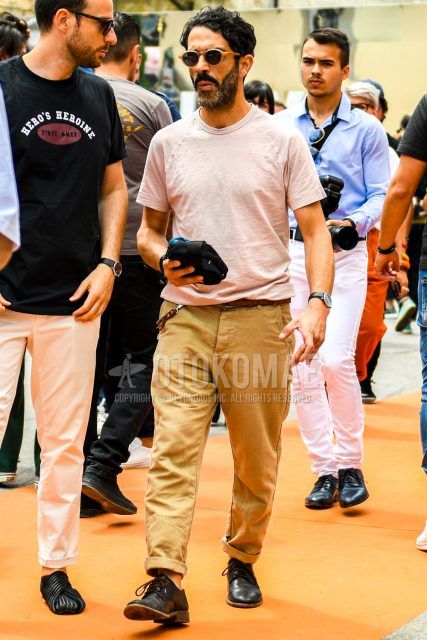 Spring, summer and fall men's coordinate outfit with plain orange sunglasses, plain pink t-shirt, plain brown leather belt, plain beige chinos and black plain toe leather shoes.