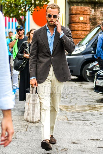 Spring, summer and fall men's coordinate outfit with gold solid color sunglasses, dark gray solid color tailored jacket, light blue solid color shirt, beige solid color chinos, brown suede shoes leather shoes, brown other loafer leather shoes.