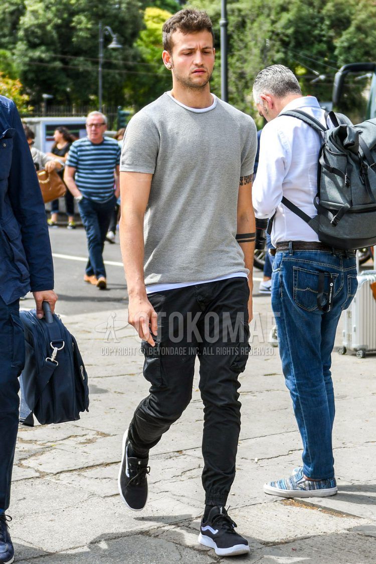 Summer men's coordinate outfit with plain gray sweater, plain white t-shirt, plain black cargo pants, plain black jogger pants/ribbed pants, plain black socks, and black low-cut sneakers by Vans.
