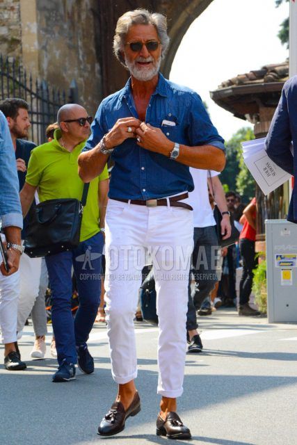 Spring/Summer/Fall men's coordinate outfit with solid color sunglasses, solid color blue denim/chambray shirt, solid color brown leather belt, solid color white denim/jeans, and brown tassel loafer leather shoes.