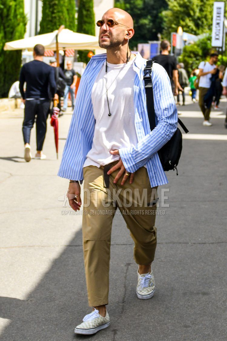 Spring, summer, and fall men's coordinate outfit with plain gold sunglasses, plain white T-shirt, white and light blue striped shirt, plain beige cargo pants, white and gray slip-on sneakers, and plain black shoulder bag.