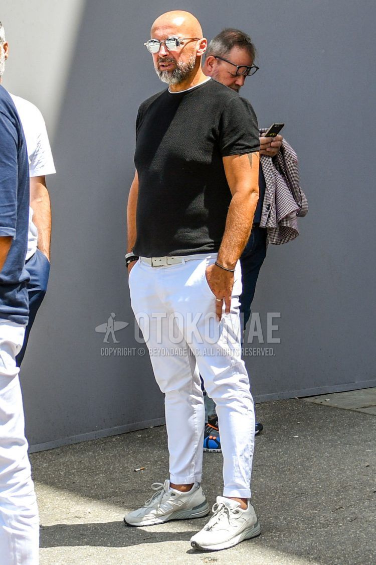 A summer men's coordinate outfit with plain sunglasses, a plain black sweater, a plain white t-shirt, a plain white leather belt, plain white cotton pants, and white low-cut sneakers.