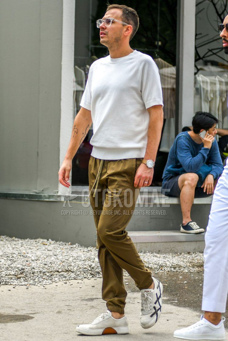 A summer men's coordinate outfit with plain glasses, plain white T-shirt, plain beige easy pants, plain chinos, and white low-cut Ermenegildo Zegna sneakers.