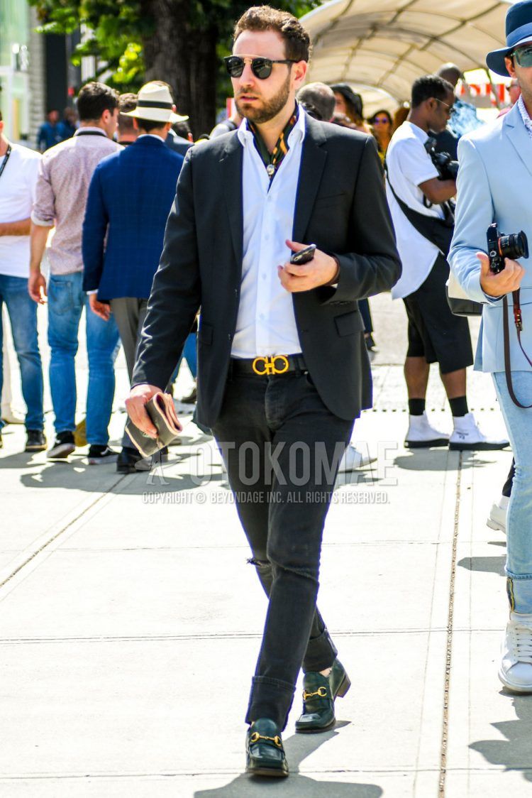 Spring/Summer/Fall men's coordinate outfit with plain sunglasses, multi-colored other bandana/neckerchief, plain black tailored jacket, plain white shirt, plain black leather belt by Salvatore Ferragamo, plain black damaged jeans, and green bit loafer leather shoes.