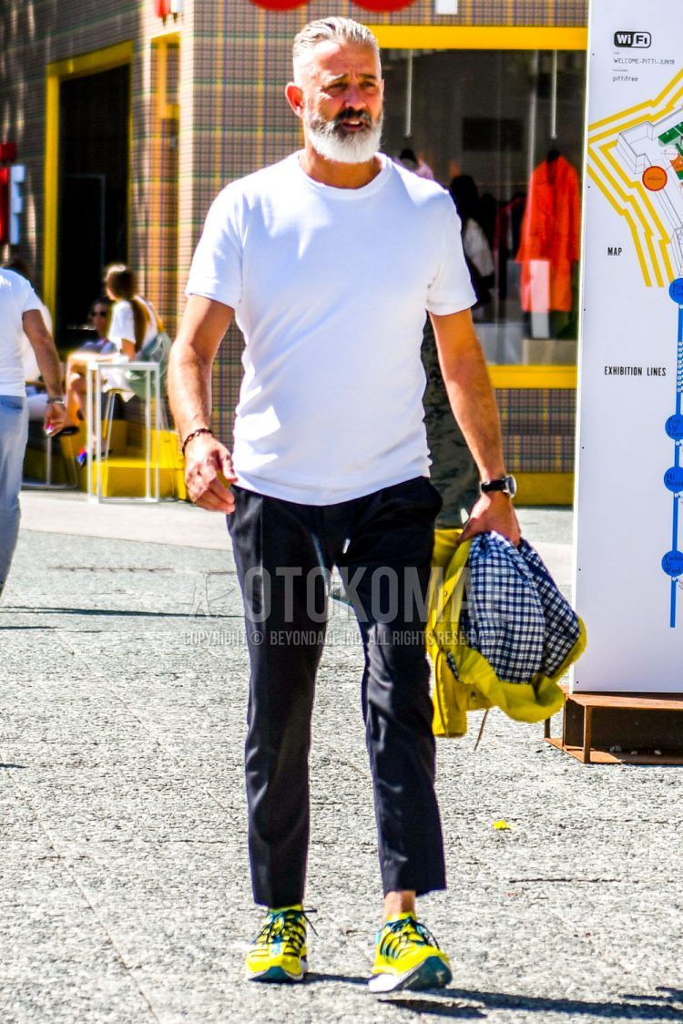 Summer men's coordinate outfit with plain white t-shirt, plain black easy pants, plain black ankle pants, and yellow multi-colored low-cut sneakers.