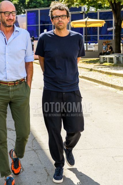A spring/summer men's coordinate outfit with plain glasses, a plain navy t-shirt, plain black easy pants, and navy low-cut sneakers.