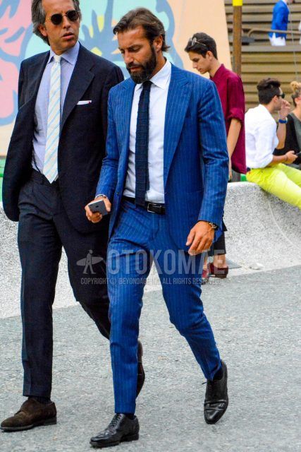 Spring, summer and fall men's coordinate outfit with plain white shirt, plain leather belt, plain socks, black wingtip leather shoes, navy-blue striped suit and plain navy-blue knit tie.