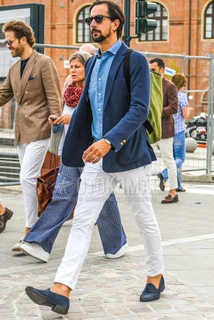 Spring, summer and fall men's coordinate outfit with plain black sunglasses, plain blue tailored jacket, plain light blue shirt, plain white cotton pants and navy suede leather shoes.
