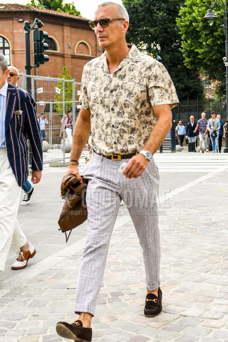 Spring and summer men's coordinate outfit with plain brown sunglasses, beige and other shirts, plain brown leather belt, gray checked slacks, and brown bit loafer leather shoes.