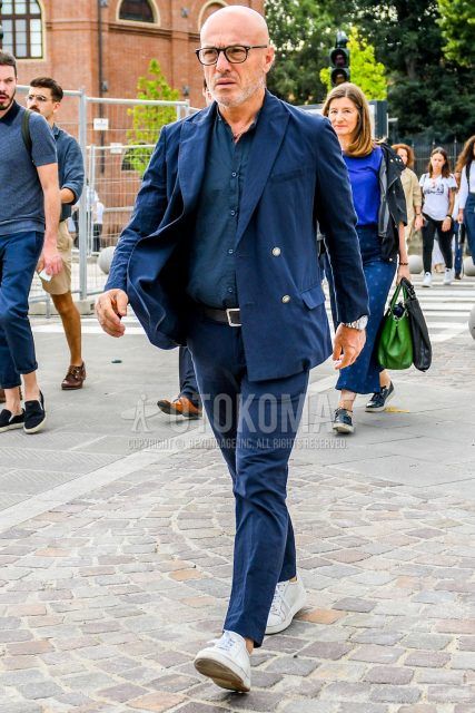 Spring, summer and fall men's coordinate outfit with plain black sunglasses, plain navy shirt, plain black leather belt, white low-cut sneakers and plain navy suit.