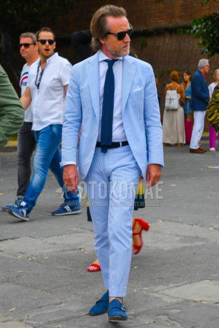 Men's spring, summer, and fall outfit with solid color sunglasses, solid color white shirt, blue monk shoes leather shoes, blue suede shoes leather shoes, light blue striped suit, and solid color blue knit tie.