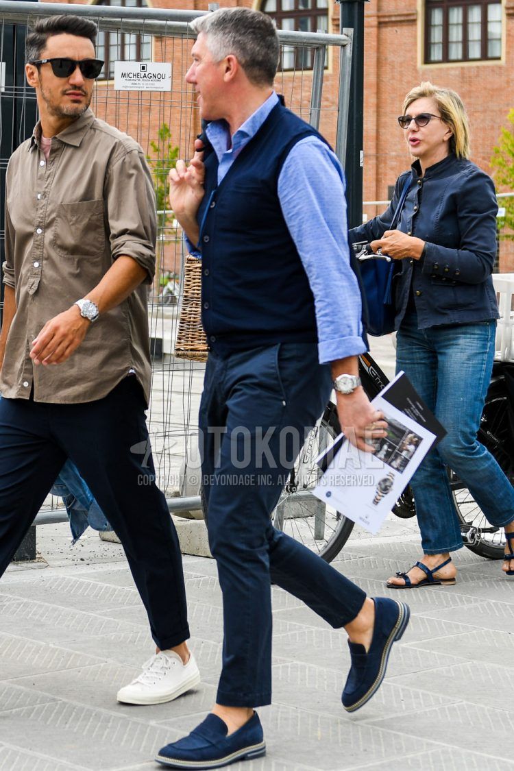 Summer-spring-fall men's coordinate outfit with plain navy gilet, plain light blue shirt, plain navy chinos, navy coin loafers leather shoes, and suede shoes leather shoes.