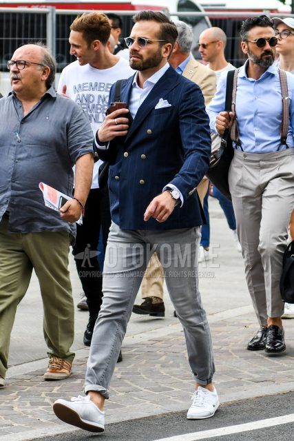 Spring/Summer/Fall men's coordinate outfit with plain sunglasses, navy striped tailored jacket, plain white shirt, plain gray denim/jeans, and white low-cut sneakers.