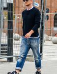 Fall/Spring men's coordinate outfit with solid color sunglasses, solid color navy sweater, solid color white t-shirt, solid color blue denim/jeans, and New Balance blue low-cut sneakers.