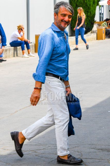 Spring, summer and fall men's coordinate outfit with plain blue denim/chambray shirt, plain black leather belt, plain white denim/jeans and brown coin loafer leather shoes.