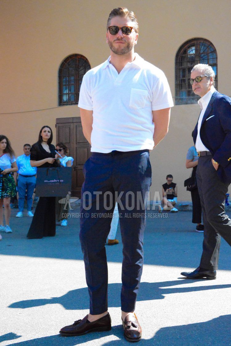 Summer men's coordinate outfit with tortoiseshell sunglasses, plain white polo shirt, plain navy ankle pants, plain chinos, and brown tassel loafer leather shoes.
