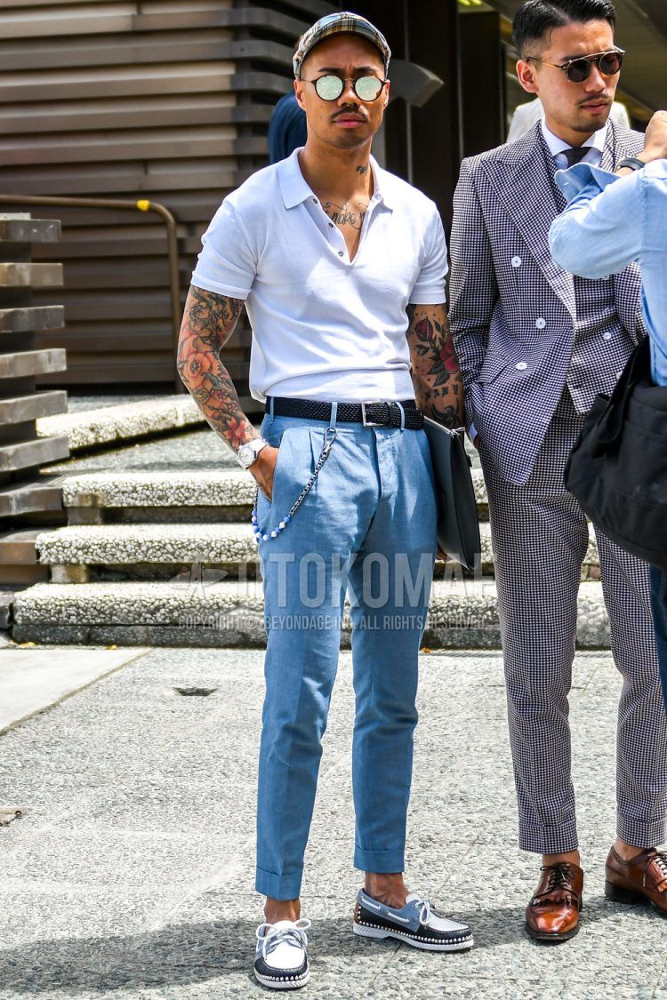 Spring/summer/fall men's coordinate outfit with light blue checked other, brown tortoiseshell sunglasses, plain white polo shirt, plain black mesh belt, plain light blue slacks, and white moccasin/deck shoe leather shoes.