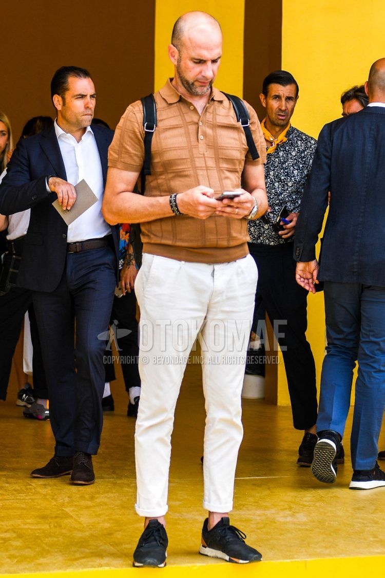 Summer men's coordinate outfit with beige other polo shirt, plain white chinos, and black low-cut sneakers.