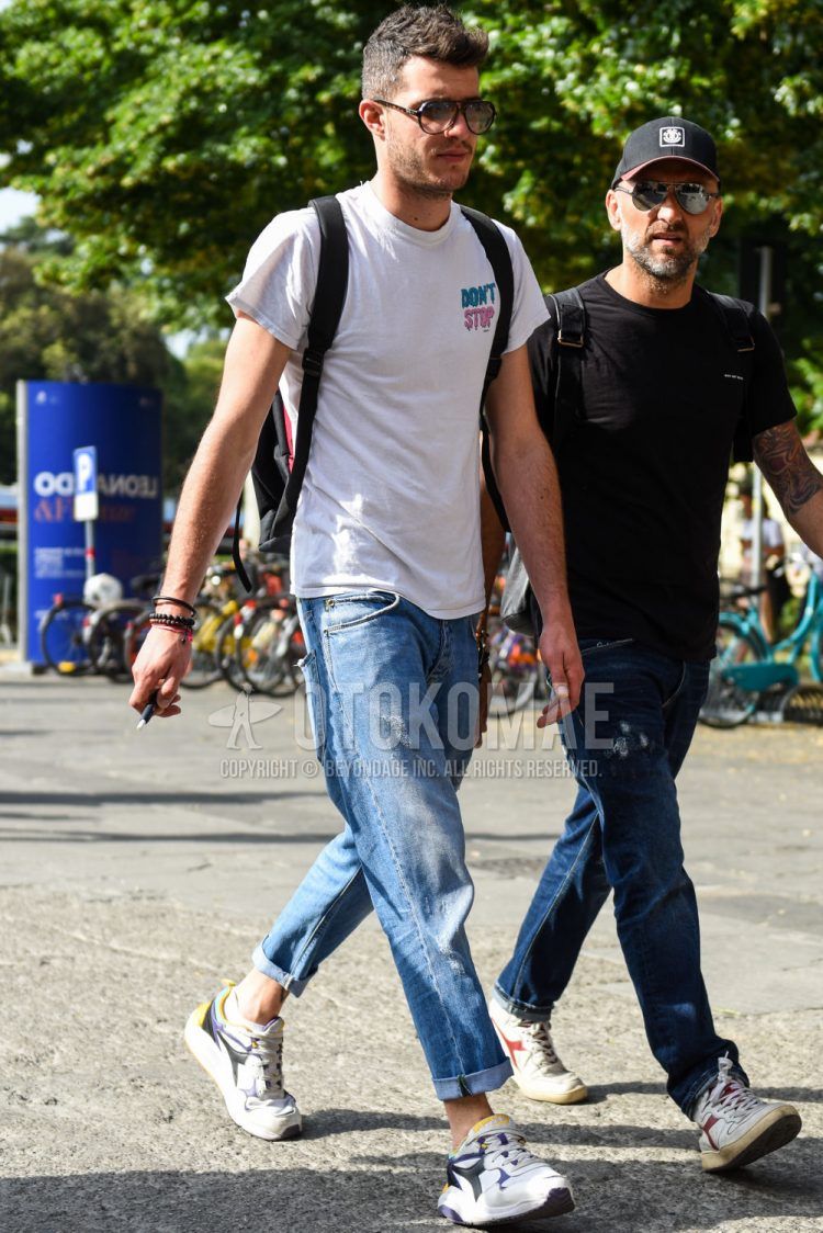Teardrop brown tortoiseshell sunglasses, white one-pointed t-shirt, plain blue denim/jeans, and white low-cut sneakers by Diadora are worn with this summer men's coordinate outfit.