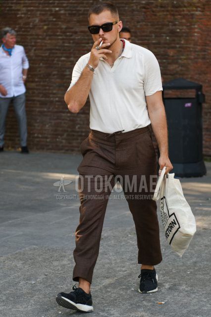 A summer men's coordinate outfit with plain black sunglasses, plain white polo shirt, plain brown slacks, and Adidas Ultra Boost black low-cut sneakers.