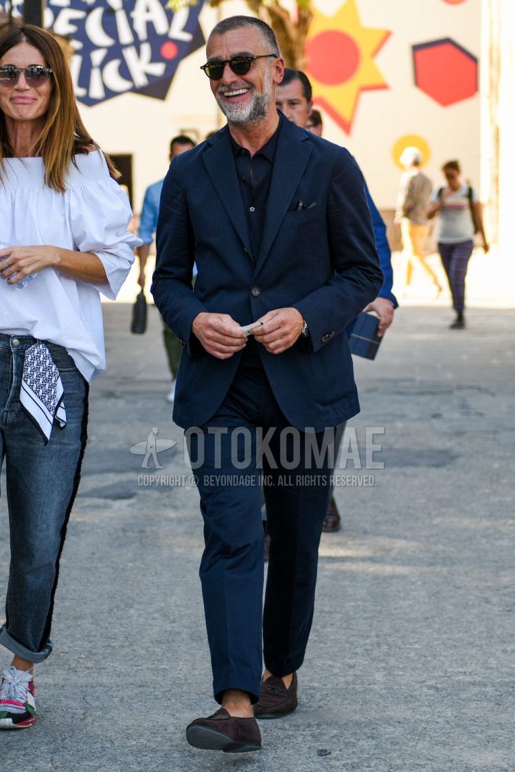 Spring, fall and summer men's coordinate outfit with plain black sunglasses, plain black shirt, suede brown and other loafer leather shoes, and plain navy suit.