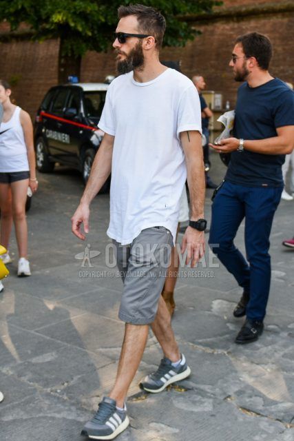 A summer men's coordinate outfit with plain black sunglasses, plain white t-shirt, plain gray shorts, and Adidas Iniki gray low-cut sneakers.