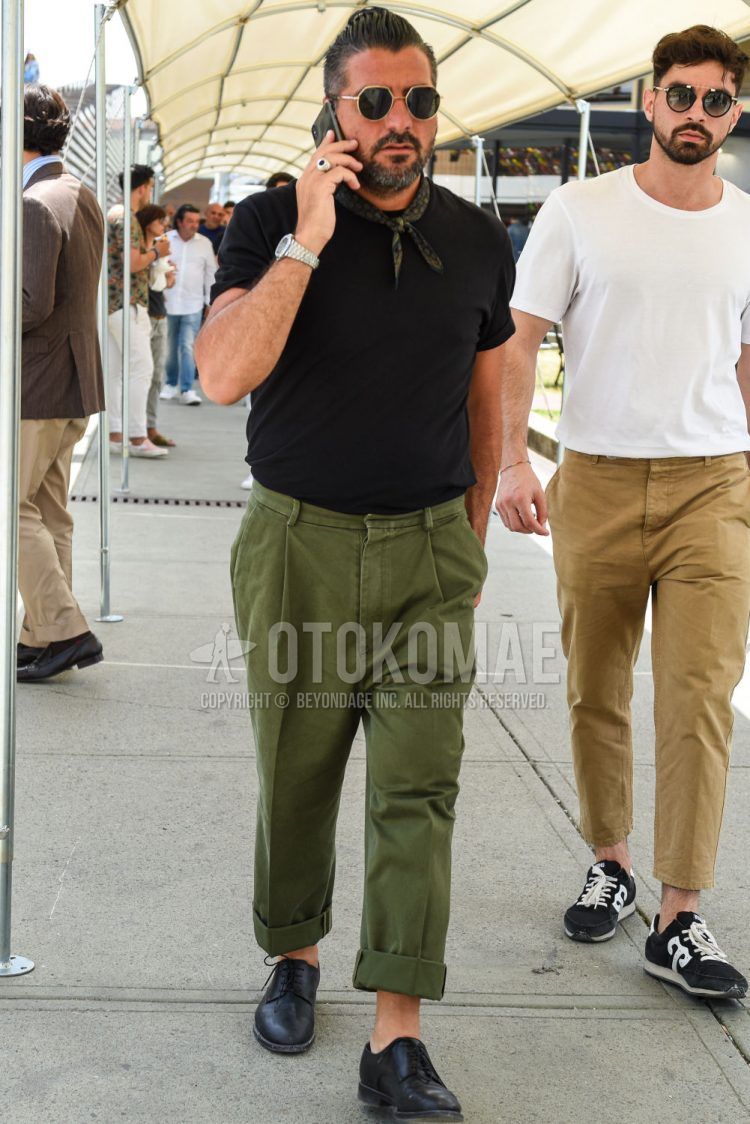 A summer men's outfit with plain black/gold sunglasses, olive green/black other bandana/neckerchief, plain black t-shirt, plain olive green chinos, and black plain toe leather shoes.