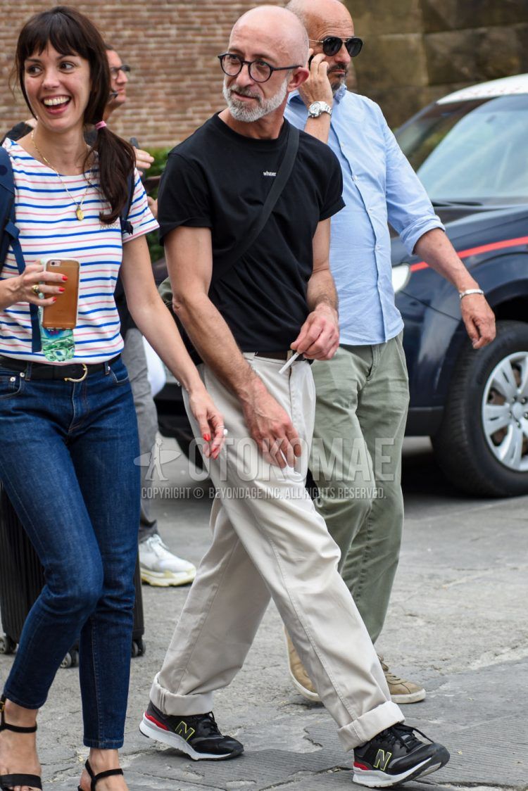 A summer men's coordinate outfit with plain black glasses, a plain black T-shirt, plain white cotton pants, and New Balance black low-cut sneakers.