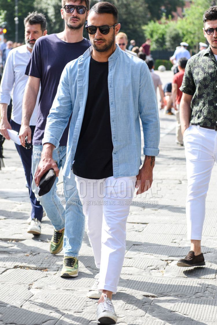 A spring/summer men's coordinate outfit with plain black Tom Ford sunglasses, plain light blue shirt with band collar, plain black t-shirt, plain white cotton pants, and white low-cut sneakers.