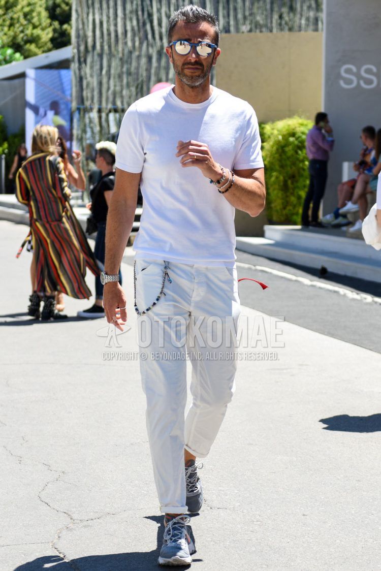 A summer men's coordinate outfit with plain gray sunglasses, a plain white t-shirt, plain white cotton pants, and Nike React Element 55 gray low-cut sneakers.