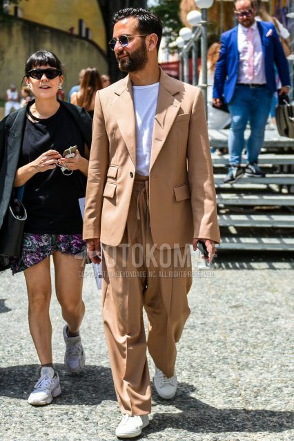 A men's spring, fall, and summer coordinate outfit with plain gold sunglasses, a plain white T-shirt, white low-cut sneakers, and a plain beige suit.