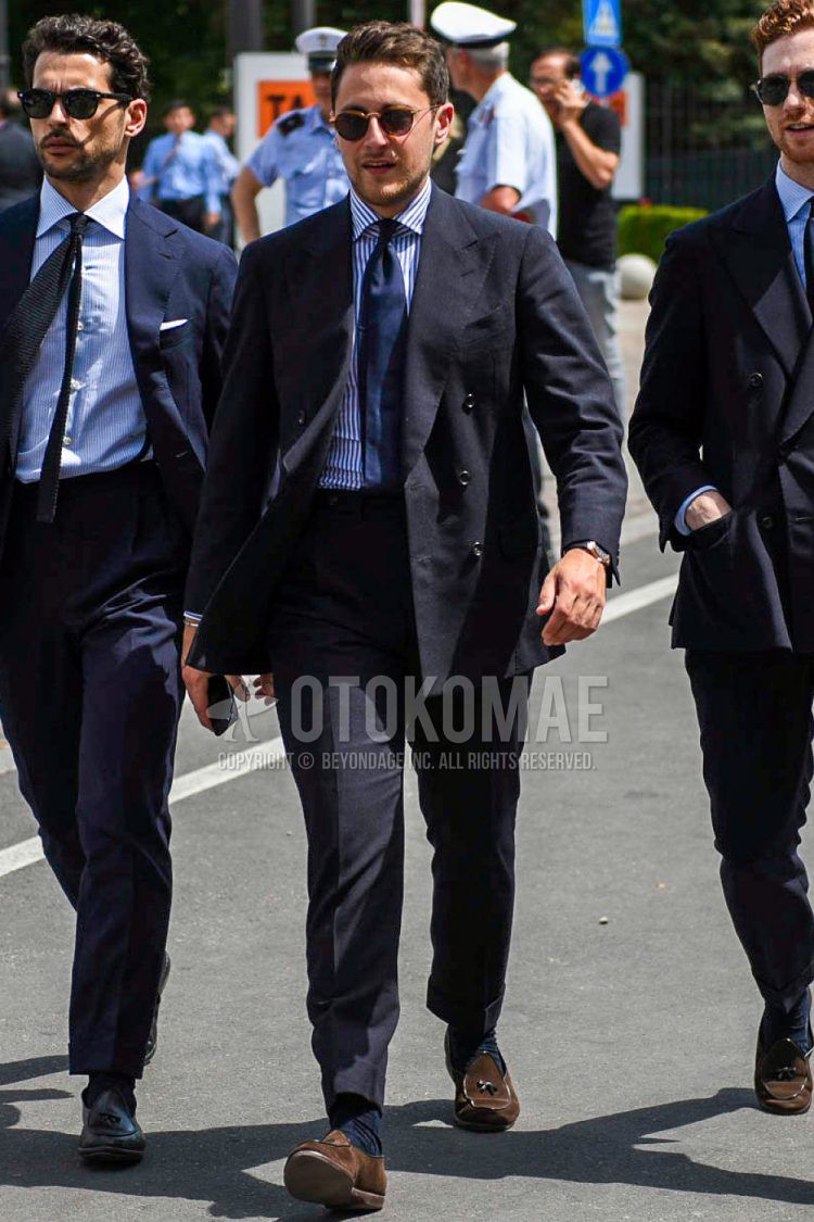 Spring and fall men's outfit with plain brown sunglasses, navy and white striped shirt, plain navy socks, brown suede shoes leather shoes, brown other loafer leather shoes, plain navy suit, and plain navy tie.