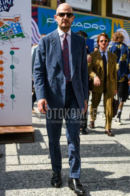 Spring, summer and fall men's coordinate outfit with plain black sunglasses, plain white shirt, black monk shoes leather shoes, plain blue suit and pink/blue paisley tie.