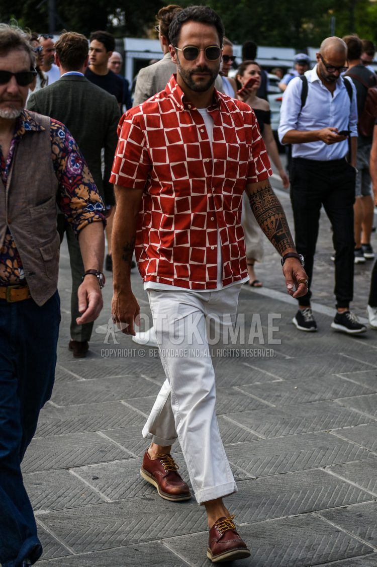 Summer men's coordinate outfit with plain black and gold sunglasses, short-sleeved red and other shirts, short-sleeved plain white T-shirt, plain beige chinos, and brown U-tip leather shoes.