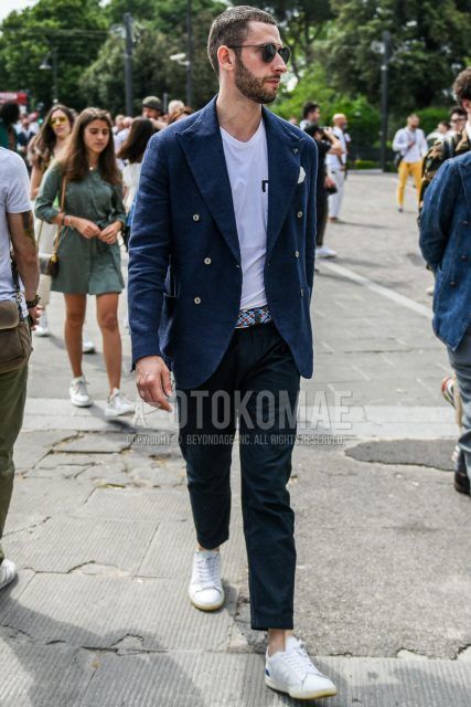 Spring, summer and fall men's coordinate outfit with plain black sunglasses, plain navy tailored jacket, plain white t-shirt, multi-colored other mesh belt, plain gray slacks and white low-cut sneakers.