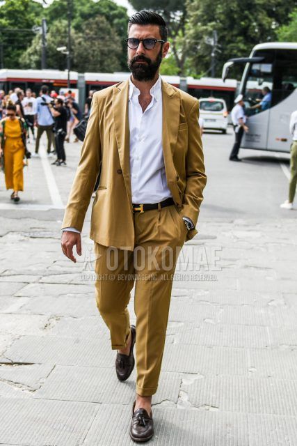 Spring, fall and summer men's coordinate outfit with plain black sunglasses, plain white shirt, plain black Hermes leather belt, brown tassel loafer leather shoes and plain beige suit.