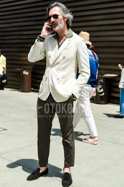 Spring and summer men's coordinate outfit with plain black teardrop Ray-Ban aviator sunglasses, plain white tailored jacket, plain linen olive green shirt, plain olive green chinos, and suede black tassel loafer leather shoes.