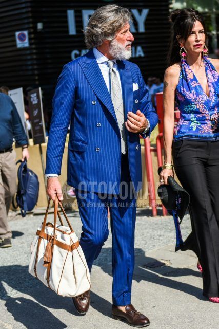 Spring, summer, and fall men's coordinate outfit with plain white shirt, brown tassel loafer leather shoes, plain white Boston bag, blue striped suit, and gray checked tie.