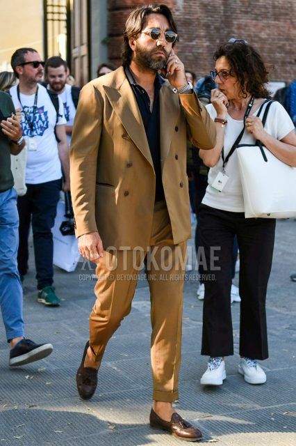 Spring, summer and fall men's coordinate outfit with gold and black solid color sunglasses, solid color black polo shirt, brown tassel loafer leather shoes and brown solid color suit.