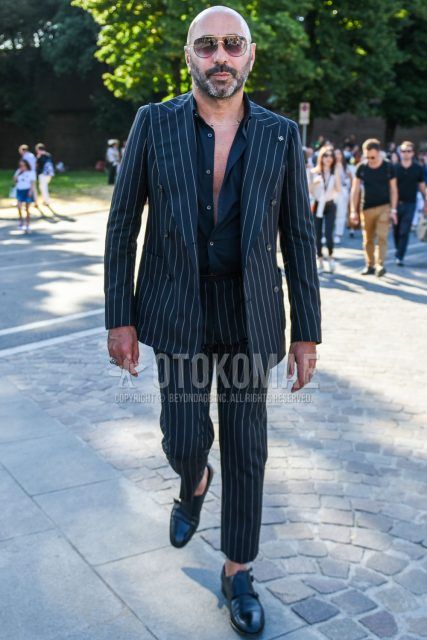 Spring, summer and fall men's coordinate outfit with plain black/brown sunglasses, plain black shirt, black monk shoes leather shoes and black striped suit.