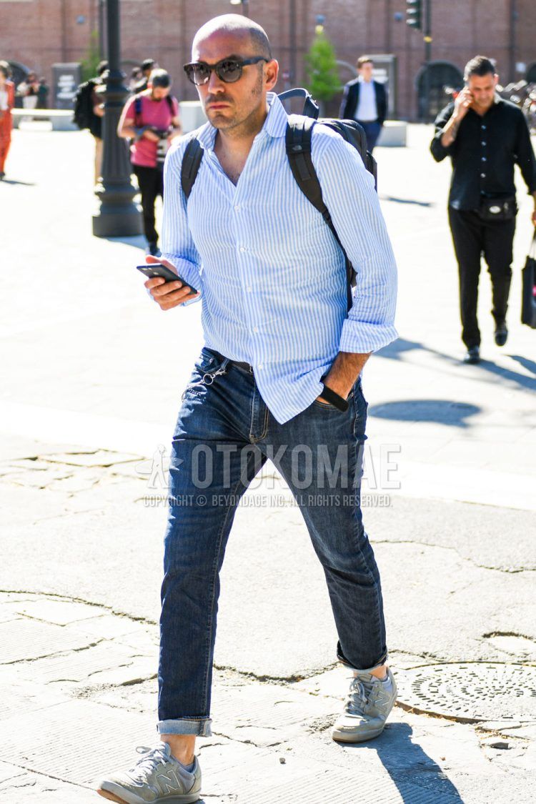 Spring/Summer/Fall men's coordinate outfit with plain black sunglasses, light blue striped shirt, light blue plain denim/jeans, and New Balance gray low-cut sneakers.